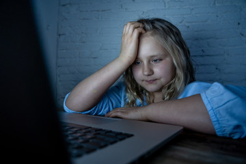 Sad young girl with laptop suffering bullying and harassment online. Cyber bullying victim