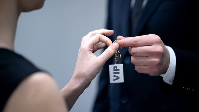 Hotel administrator giving woman keys to VIP apartment, luxury hotel service