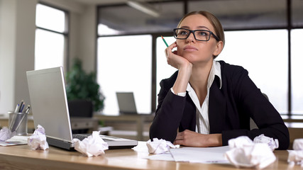 Bored woman thinking over startup in office, lacking new ideas, unmotivated
