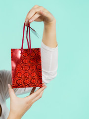 Woman holds red gift bag in hand