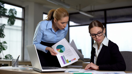 Manager reminding colleague about deadline, angry about charts with low revenues