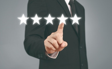Hand touching five star symbol to increase rating