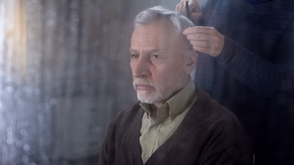 Woman combing senior husband hair, old age disease recovery, family support