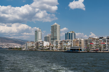 View from a boat of Konak district waterfront with buildings and Alsancak ferry port in Izmir, Turkey.