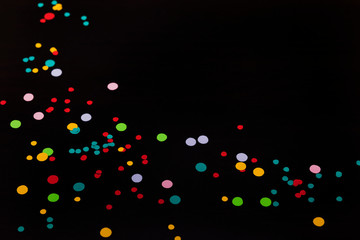 Colorful confetti on black background with space for copy text