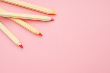 Pink background with wooden colorful ordinary pencils. Back to school.