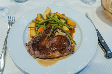 Delicious grilled beefsteak and roasted potatoes on white plate