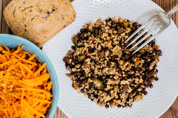Assiette de grains de millet et couscous et bol de carottes râpées