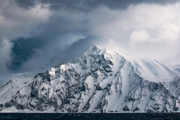 rocks on the mountains of one of the Kuril Islands in the winter during a snow storm