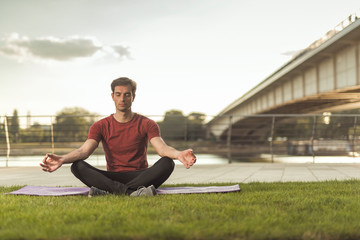 Fototapeta na wymiar Doing yoga on a sunny summer day in the park