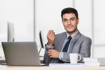 Businessman touch his wrist in modern office.