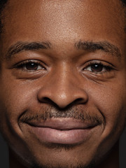 Close up portrait of young and emotional african-american man. Highly detail photoshot of male model with well-kept skin and bright facial expression. Concept of human emotions. Looking at camera.