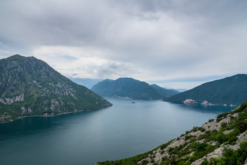 Montenegro, View over bay of kotor from above risan town green cliffs and mountains on cloudy day