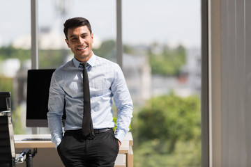 Businessman crossed arms and standing in office..