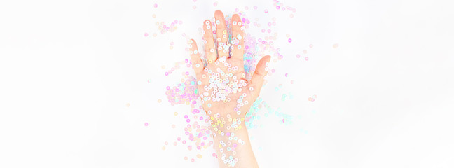 Naklejka premium Pearl pastel confetti sparkles with woman hand