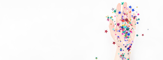 Woman hand with festive color star confetti
