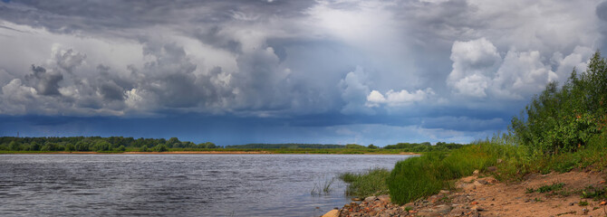 Summer panorama with river and picturesque, cloudy sky