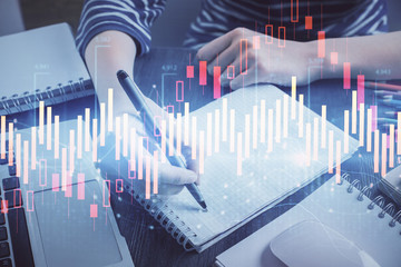 Financial chart drawn over hands taking notes background. Concept of research. Double exposure