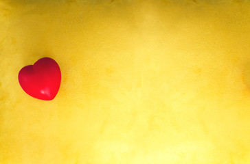 Corazón rojo sobre fondo de tela amarilla
