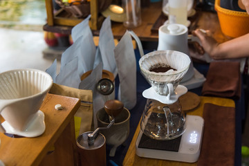 Close up of filter coffee maker, kettle with thermometer and digital scale on wooden table.Barista brewing coffee, method pour over, drip coffee.