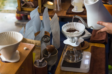 Close up of filter coffee maker, kettle with thermometer and digital scale on wooden table.Barista brewing coffee, method pour over, drip coffee.