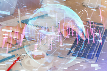 Forex graph with businessman working on computer in office on background. Concept of hardworking. Double exposure.