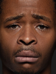 Close up portrait of young and emotional african-american man. Highly detail photoshot of male model with well-kept skin and facial expression. Concept of human emotions. Upset, sad, demotivated.