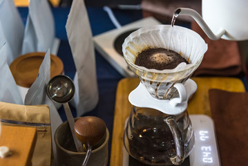 Close up of filter coffee maker, kettle with thermometer and digital scale on wooden table.Barista brewing coffee, method pour over, drip coffee.
