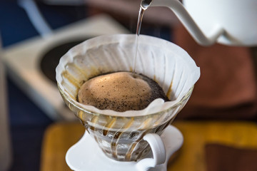 Close up of filter coffee maker, kettle with thermometer and digital scale on wooden table.Barista brewing coffee, method pour over, drip coffee.