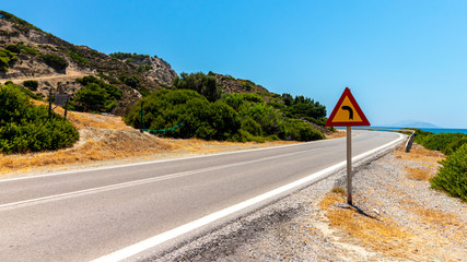 Lonely road with road sign on Rhodes, Greece
