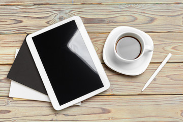 Work space. Digital tablet and coffee cup with supplies, still life