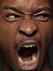 Close up portrait of young and emotional african-american man. Highly detail photoshot of male model with well-kept skin and bright facial expression. Concept of human emotions. Angry screaming.