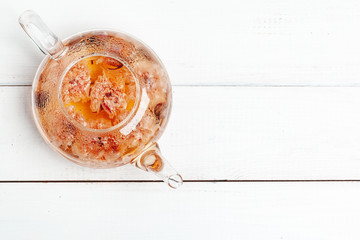 Kettle of herbal tea close up on wooden table top view