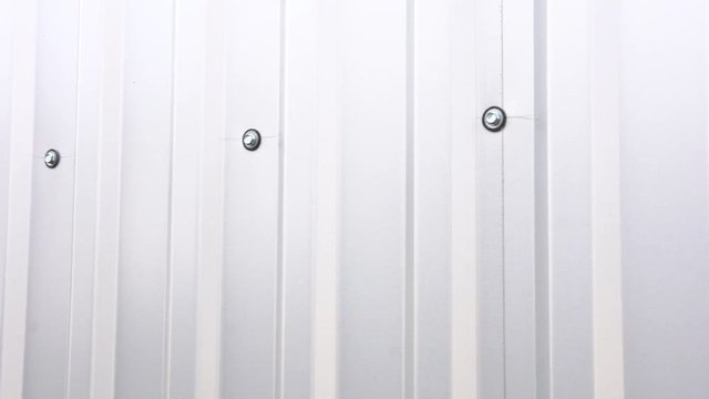 Bolts on infinite long mounted corrugated sheet. White Roof tile sheets, Poly carbonate roof. Seamless metal profiled panel.