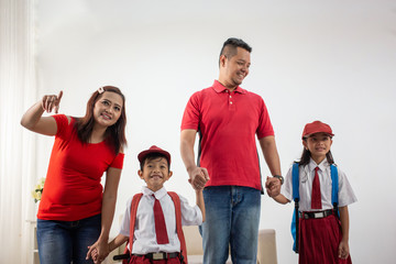 elementary students wearing uniform and parent walking together to school