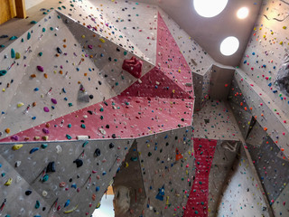 Artificial indoor climbing wall full of hand grips.