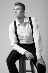 young serious man on chair, close-up portrait, fashion model, black and white photo