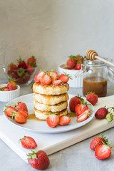 Cottage cheese pancakes syrniki with strawberries and honey. The concept of tasty healthy summer Breakfast. Copy space, side view.