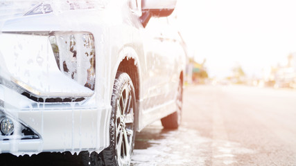Outdoor car wash with active foam soap outdoor. commercial cleaning washing service concept. Leave space for writing messages.