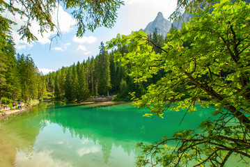Fototapeta premium Turquoise water of the lake Lago di Braies, Pragser Wildsee surrounded by pine forest and mountains in the Prags Dolomites in South Tyrol, Italy, Europe
