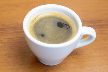 Cup of espresso coffee on wooden table close up