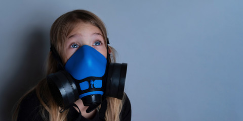 Young girl wearing gasmask, respirator portrait. Effects of worldwide air pollution, industrial...