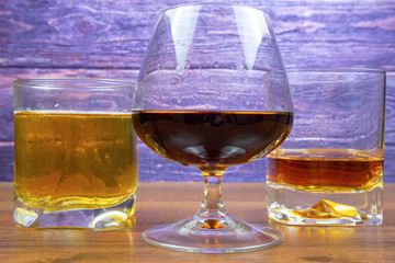 Three glasses with different colored alcoholic drinks