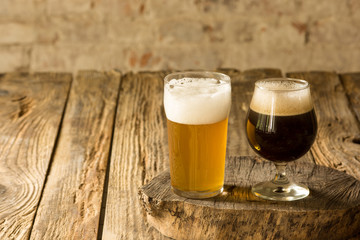 Glasses of different kinds of dark and light beer on wooden table in line. Cold delicious drinks prepared for a big friend's party. Concept of drinks, fun, meeting, oktoberfest. Copyspace.