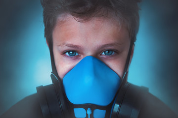 Young boy wearing gasmask, respirator portrait. Effects of worldwide air pollution, industrial...