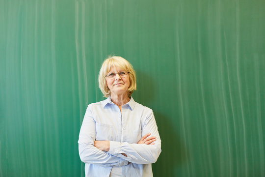 Senior woman as teacher with chalkboard