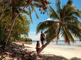 Lovely couple standing near palm trees in paradise Onok Island in Balabac Palawan in Philippines