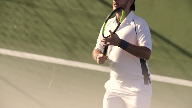 Professional sportsman playing tennis on a hardcourt outdoors. Professional tennis player hitting forehands and backhand on hard court.