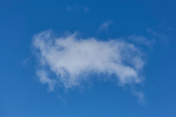 Background of a one single cumulus cloud with a blue clear sky