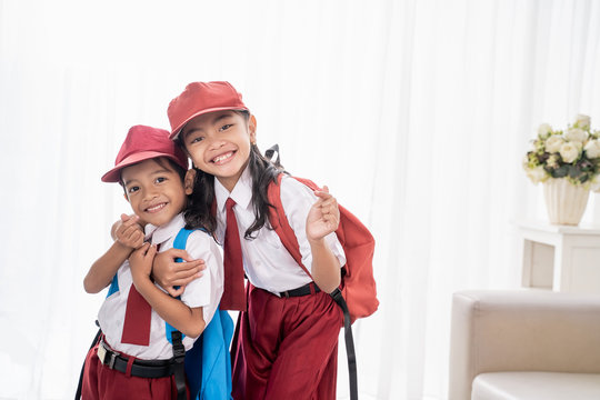 lovely two elementary student smiling to camera over white background